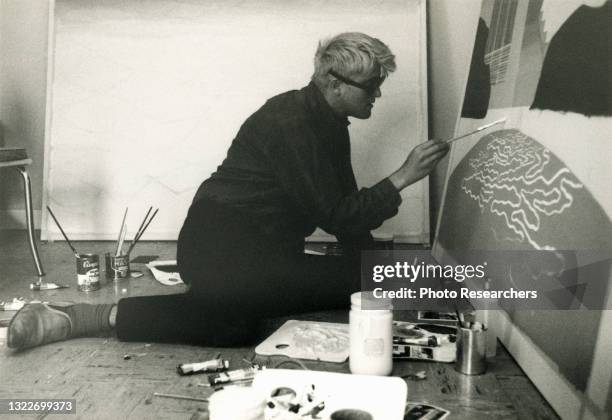 View of British Pop artist David Hockney as he paints in his home studio, Los Angeles, California, 1966.