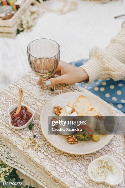 essen im freien - frauenhand mit einem glas weißwein - camembert stock-fotos und bilder