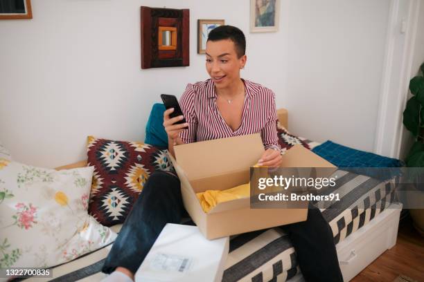 attractive caucasian woman shopping for clothes from home - returning package stock pictures, royalty-free photos & images