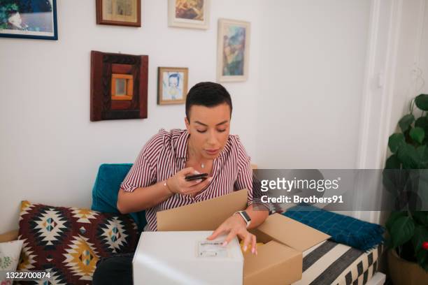 attractive caucasian woman shopping for clothes from home - returning package stock pictures, royalty-free photos & images