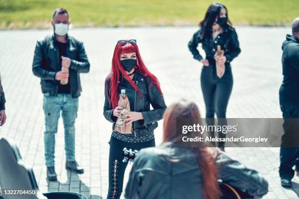 gothic redhead female enjoying busker's performer and putting money in guitar case - metalhead stock pictures, royalty-free photos & images