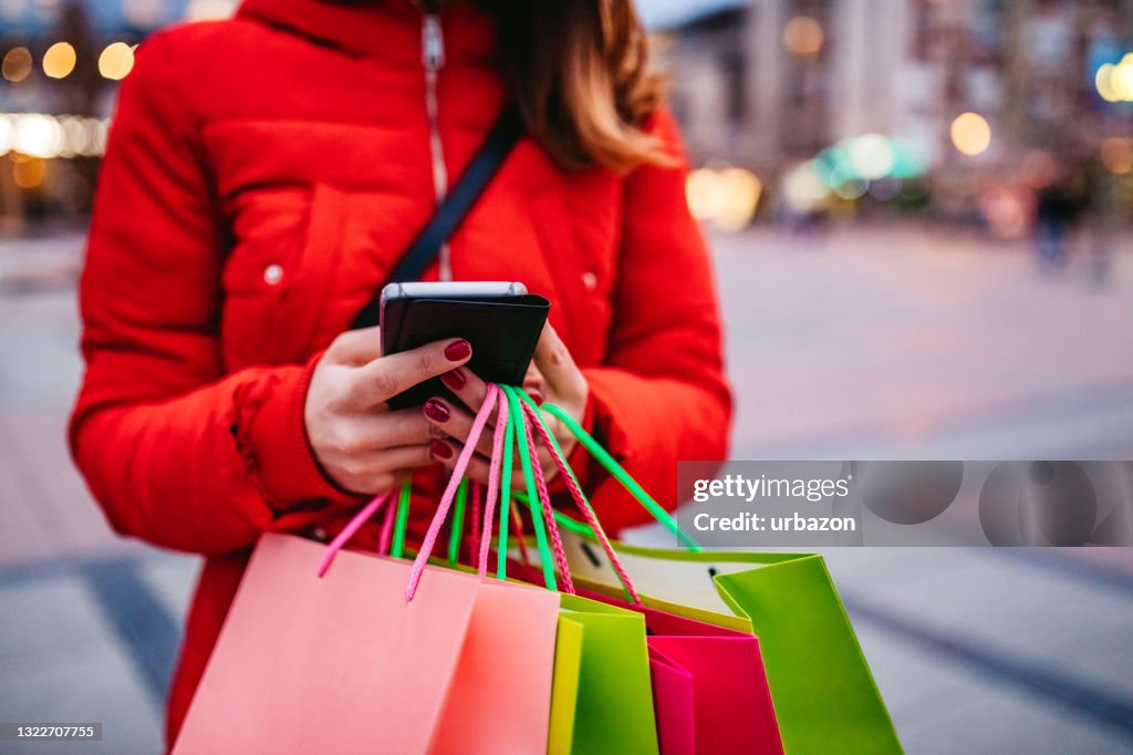 Woman with shopping bags using phone