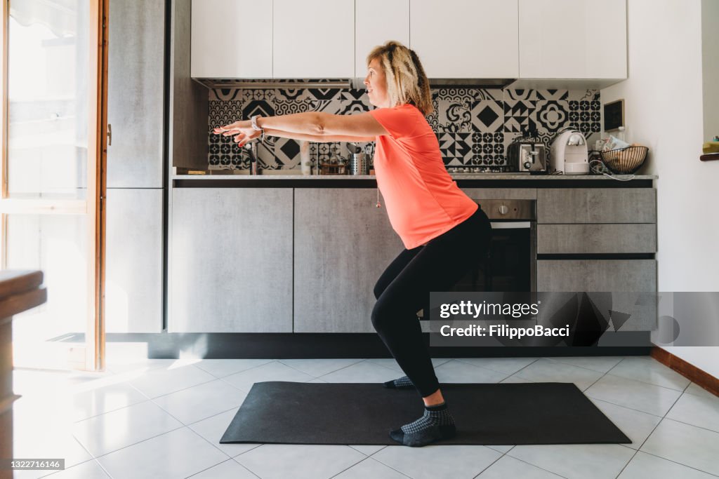 Pregnant woman exercising at home in the kitchen
