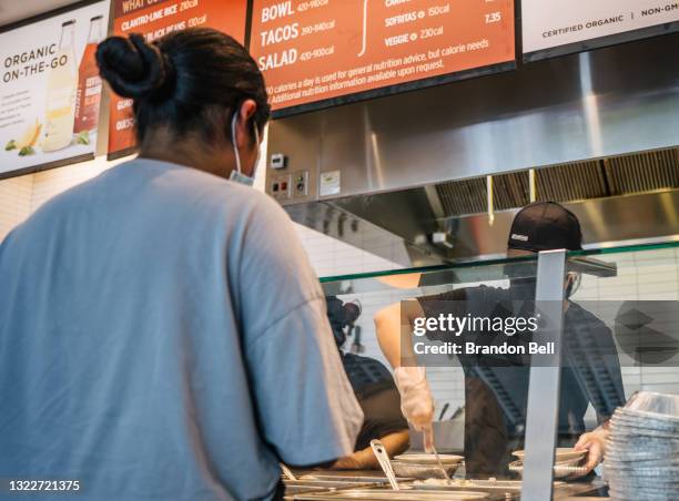 Woman waits in line for food at a Chipotle Mexican Grill on June 09, 2021 in Houston, Texas. Menu prices at the Chipotle Mexican Grill have risen by...