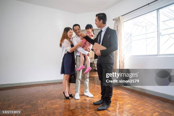 real estate agent is giving key for a new house to happy couple - generation contract stock pictures, royalty-free photos & images