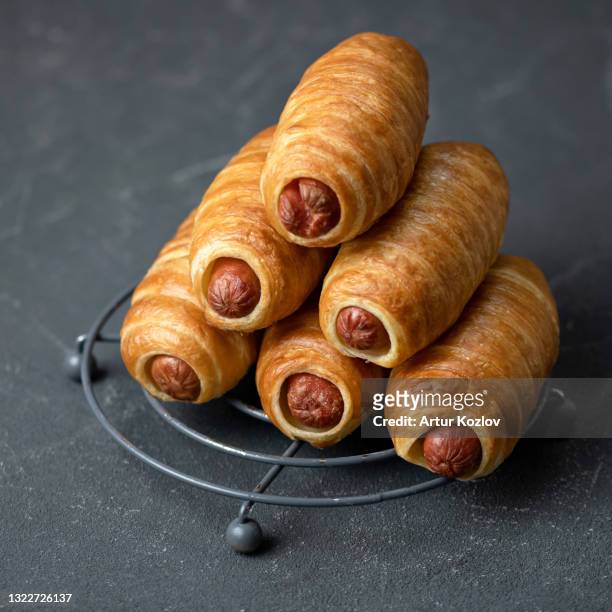 pyramid of hot dogs snack on gray background, close up. fresh baked goods, sausage in puff pastry. junk food concept. copy space. square format. soft focus - puff pastry stock pictures, royalty-free photos & images