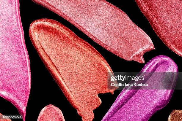 red, pink, burgundy lipstick smears on black background. isolated for design. lip gloss samples are smudged. beauty cosmetic banner. makeup and skin care products. closeup. - paintbrush palette stock pictures, royalty-free photos & images