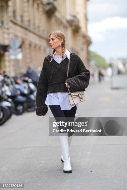 Xenia Adonts wears silver earrings, a pearls necklace, a white long oversized shirt from Attire The Studio, a dark gray woven wool oversized V-neck...