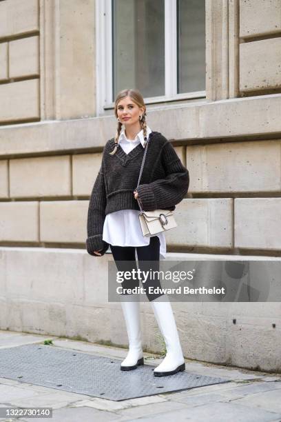 Xenia Adonts wears silver earrings, a pearls necklace, a white long oversized shirt from Attire The Studio, a dark gray woven wool oversized V-neck...