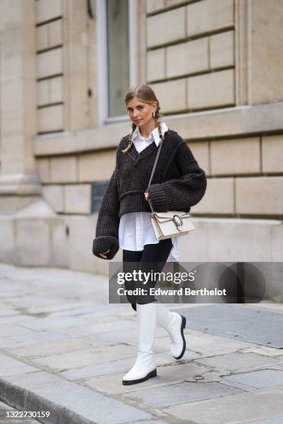 Xenia Adonts wears silver earrings, a pearls necklace, a white long oversized shirt from Attire The Studio, a dark gray woven wool oversized V-neck...