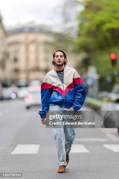 Alejandro Acero wears a black and white stripped Maison Kitsune t-shirt, a white latte red and royal blue leather oversized Isabel Marant jacket,...