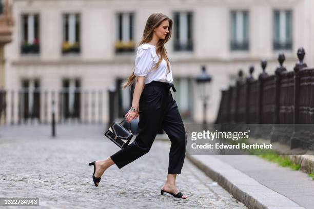 Fashion blogger @hippolyt.e wears a white t-shirt/top with pearls detail on the collar and puffy sleeves from Simone Rocha, black knotted belted...