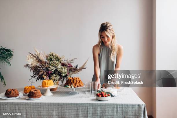 party decorator: a beautiful blonde woman setting the table for a birthday party - party host imagens e fotografias de stock