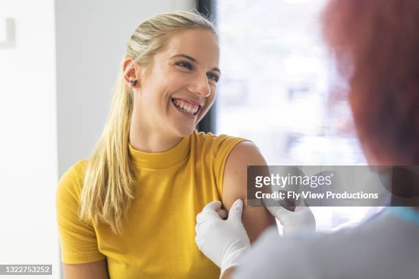 ein glücklicher patient, der gerade den impfstoff erhalten hat - grippevirus stock-fotos und bilder