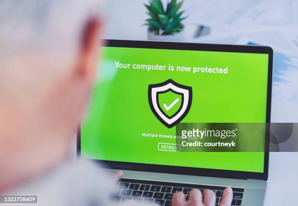 der ausgereifte geschäftsmann, der sich einen antiviren-sicherheitsanmeldebildschirm auf einem computer ansieht. - antivirus software stock-fotos und bilder