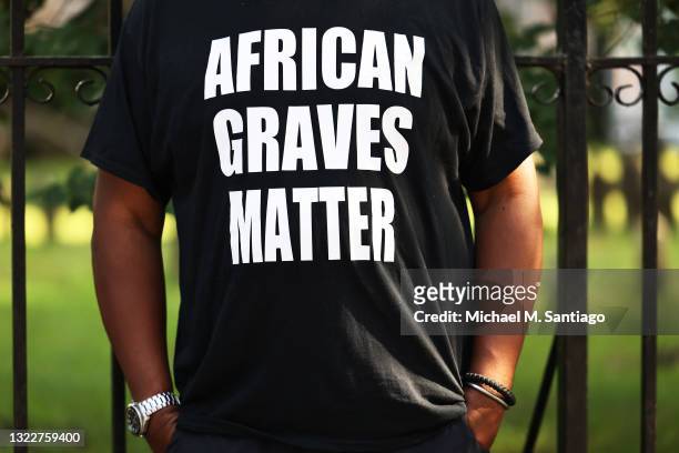 The Rev. Gregory S. Livingston wears an "African Graves Matter" T-shirt to a gathering to bring attention to an empty lot, believed to be a burial...