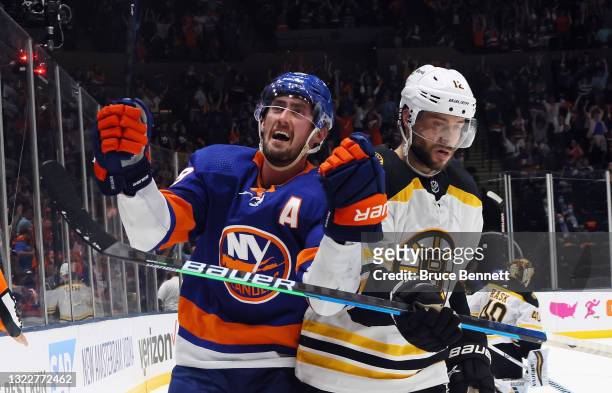 Brock Nelson of the New York Islanders scores at 12:39 of the second period against the Boston Bruins as Craig Smith moves away in Game Six of the...