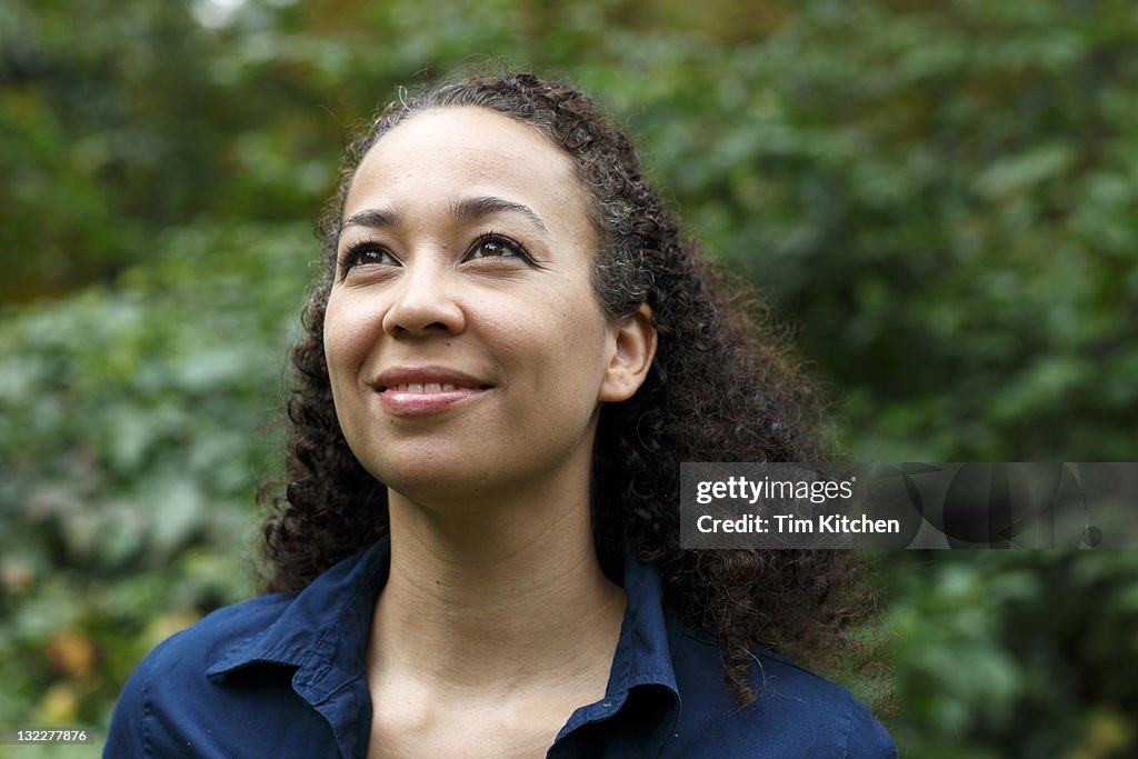 Mixed race woman in nature, smiling