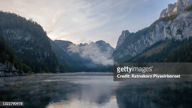 aerial drone sunrise fog and mist scene landscape of mountain and lake at gosausee lake, gosauseen are three lakes in the south-western, alpine part of upper austria - bergsee stock-fotos und bilder