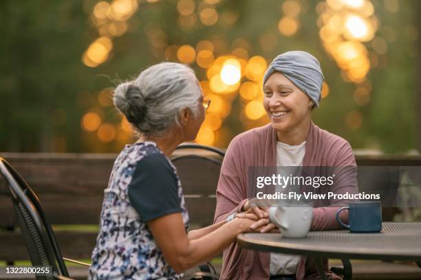 young mixed race woman with cancer spending quality time with her mom - cancer patient with family stock pictures, royalty-free photos & images