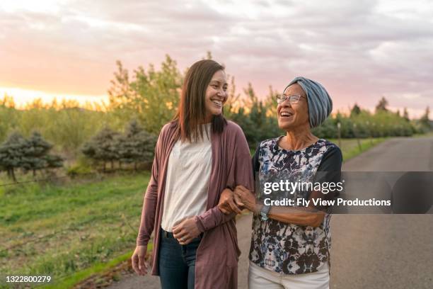 hermosa madre e hija de raza mixta relajándose al aire libre juntos - best friends women fotografías e imágenes de stock