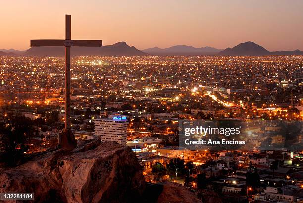 cross with cityscape at night - hermosillo ストックフォトと画像