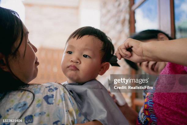 grandmother giving her grandson haircut at home - glamourous granny stock pictures, royalty-free photos & images