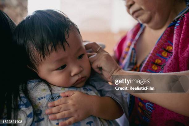 grandmother giving her grandson haircut at home - glamourous granny stockfoto's en -beelden