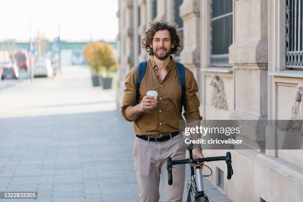 front view of a handsome young businessman holding a coffee cup - suave stock pictures, royalty-free photos & images