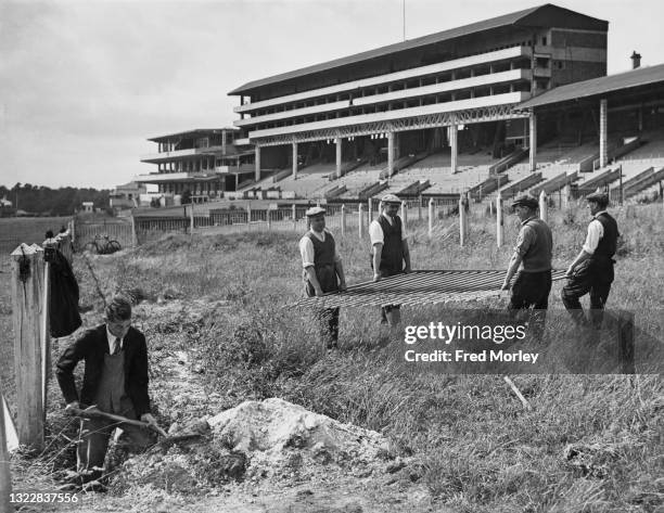 Workers begin to dismantle the spectator railings near the main grandstand of the Epsom racecourse to reclaim the steel and iron as part of the...