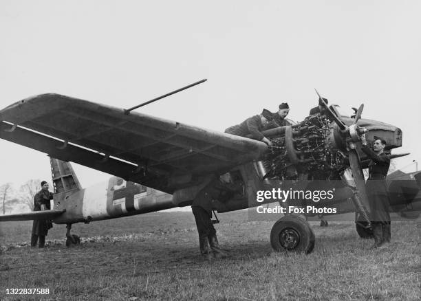 Royal Air Force groundcrew technicians of No1426 Flight RAF and known as the Rafwaffe examine the engine and propeller on captured Nazi Luftwaffe...