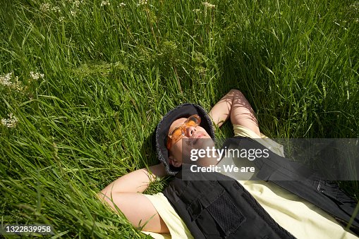 Man lying back in long grass enjoying the sunshine Man lying back in long grass enjoying the sunshine