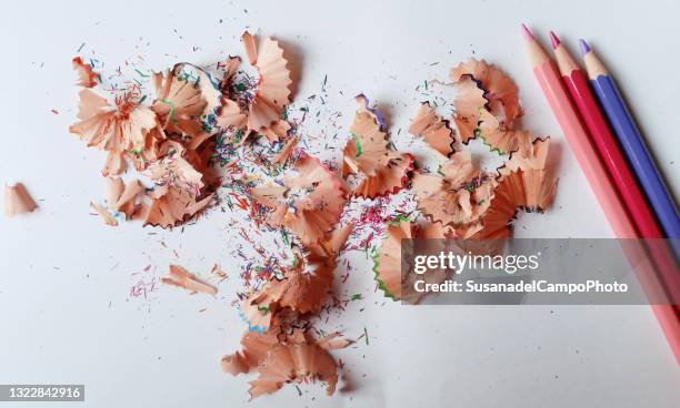 overhead view of coloured pencils and pencil shavings on a table - pencil shavings stock pictures, royalty-free photos & images