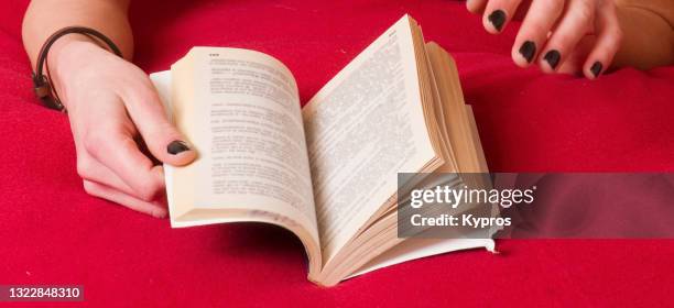 woman's hand holding a paperback book - paperback stock pictures, royalty-free photos & images