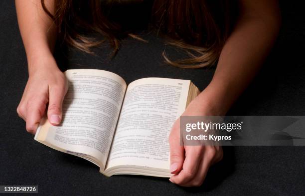 woman's hand holding a paperback book - libro in brossura foto e immagini stock