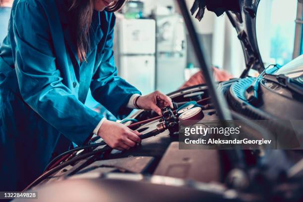 female car mechanic examining car freon pressure - gas compressor stock pictures, royalty-free photos & images
