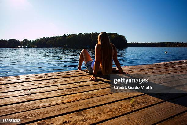 women sitting on lake landing stage. - neuruppin stock pictures, royalty-free photos & images