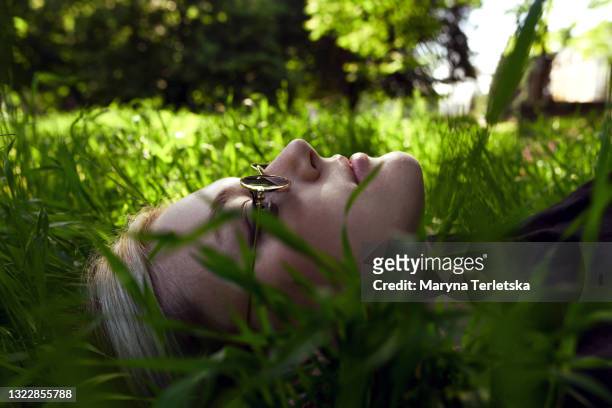 profile portrait of a young girl in the grass. - relaxation therapy stock pictures, royalty-free photos & images