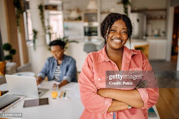 young businesswoman posing in her new home office setup - start a new business stock pictures, royalty-free photos & images