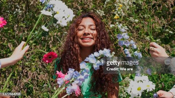 portrait of woman surrounded by flowers - standing out from the crowd flower stock pictures, royalty-free photos & images