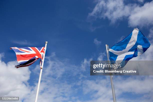 a british flag and scottish flag against a blue sky - referendum signage and symbols stock-fotos und bilder