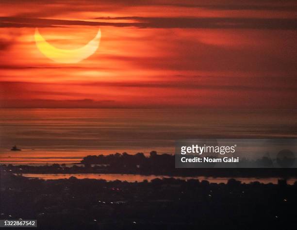The sun rises over New York City during a solar eclipse on June 10, 2021 as seen from The Edge observatory deck at The Hudson Yards. Northeast states...