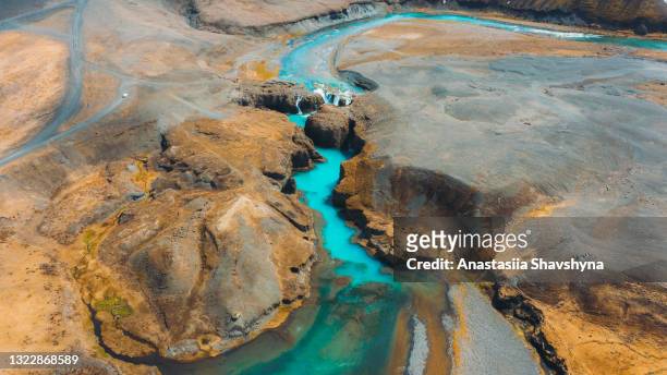 toneel luchtmening van de autoparkeren bij de verre turkooise waterval in de bergcanion in ijsland - geologie stockfoto's en -beelden