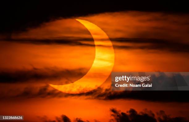 The sun rises over New York City during a solar eclipse on June 10, 2021 as seen from The Edge observatory deck at The Hudson Yards. Northeast states...