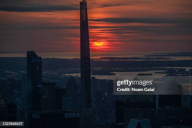 The sun rises over New York City during a solar eclipse on June 10, 2021 as seen from The Edge observatory deck at The Hudson Yards. Northeast states...