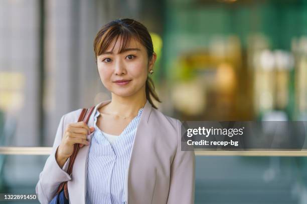 街の幸せで自信に満ちたビジネスウーマンの肖像画 - 女性　日本人　笑顔　30代 ストックフォトと画像