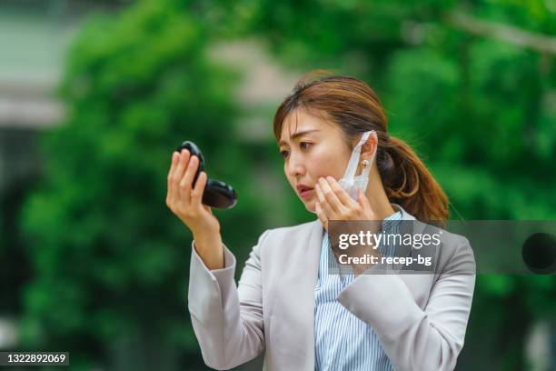 geschäftsfrau entfernt schützende gesichtsmaske und überprüft ihre haut - removing make up stock-fotos und bilder