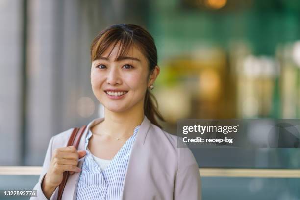 街の幸せで自信に満ちたビジネスウーマンの肖像画 - 女性　日本人　笑顔　30代 ストックフォトと画像
