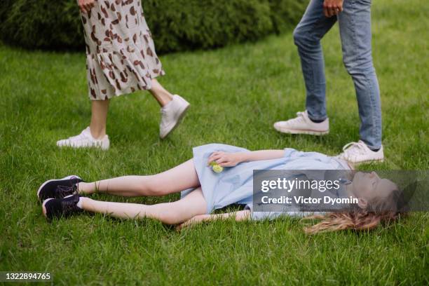 abandoned girl in the blue dress lays on the lawn - unconscious stock pictures, royalty-free photos & images