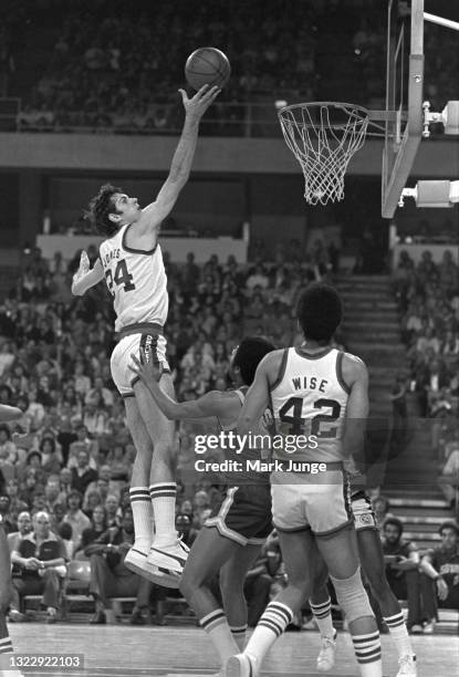 Denver Nuggets forward Bobby Jones attempts a floating layup over Seattle Supersonics guard Fred Brown during an NBA basketball game at McNichols...